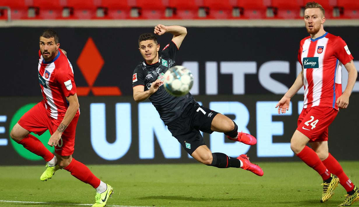 Gelandang werder Bremen, Milot Rashica, berebut bola dengan pemain Heidenheim 1846 pada laga lay-off leg kedua di Voith-Arena, Selasa (7/7/2020) dini hari WIB. Bremen bermain imbang 2-2 atas Heidenheim. (AFP/Kai Pfaffenbach/pool)