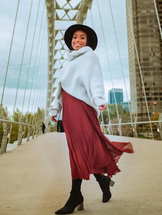 Inspirasi outfit musim dingin lainnya, padukan turtleneck knit dengan rok plisket maroon. Aksesori berupa topi boater bikin lookmu makin modis (Instagram/aysaharun).