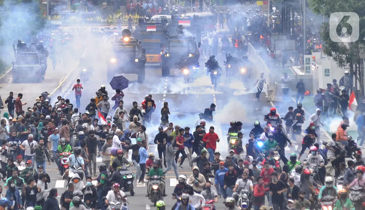 Petugas Brimob Polri menembakkan gas air mata untuk membubarkan massa usai terjadi lemparan batu di Jalan MH Thamrin, Jakarta, Selas (13/10/2020). Massa pengunjuk rasa yang menolak Omnibus Law akhirnya dibubarkan aparat. (merdeka.com/Arie Basuki)