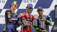 Pembalap Ducati, Francesco Bagnaia (tengah), menjuarai MotoGP San Marino, Minggu (19/9/2021). Dia berpose di podium bersama Fabio Quartararo (kiri) dan Enea Bastianini. (AP Photo/Antonio Calanni)