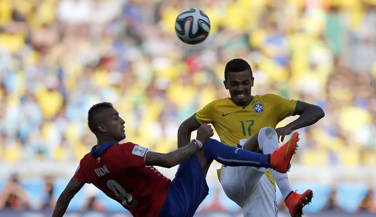 Gelandang Timnas Chile, Arturo Vidal (kiri) berusaha merebut bola dari pemain tengah Brasil, Luiz Gustavo, saat berlaga di babak 16 besar Piala Dunia 2014 di Stadion Mineirao, Belo Horizonte, (28/6/2014). (REUTERS/Sergio Perez)