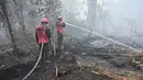 Petugas pemadam kebakaran berupaya melakukan pemadaman di tengah pekatnya asap kebakaran di Kampar, provinsi Riau pada 17 September 2019. Kebakaran hutan dan lahan (karhutla) yang masih terjadi membuat sejumlah wilayah di Provinsi Riau terpapar kabut asap. (ADEK BERRY / AFP)