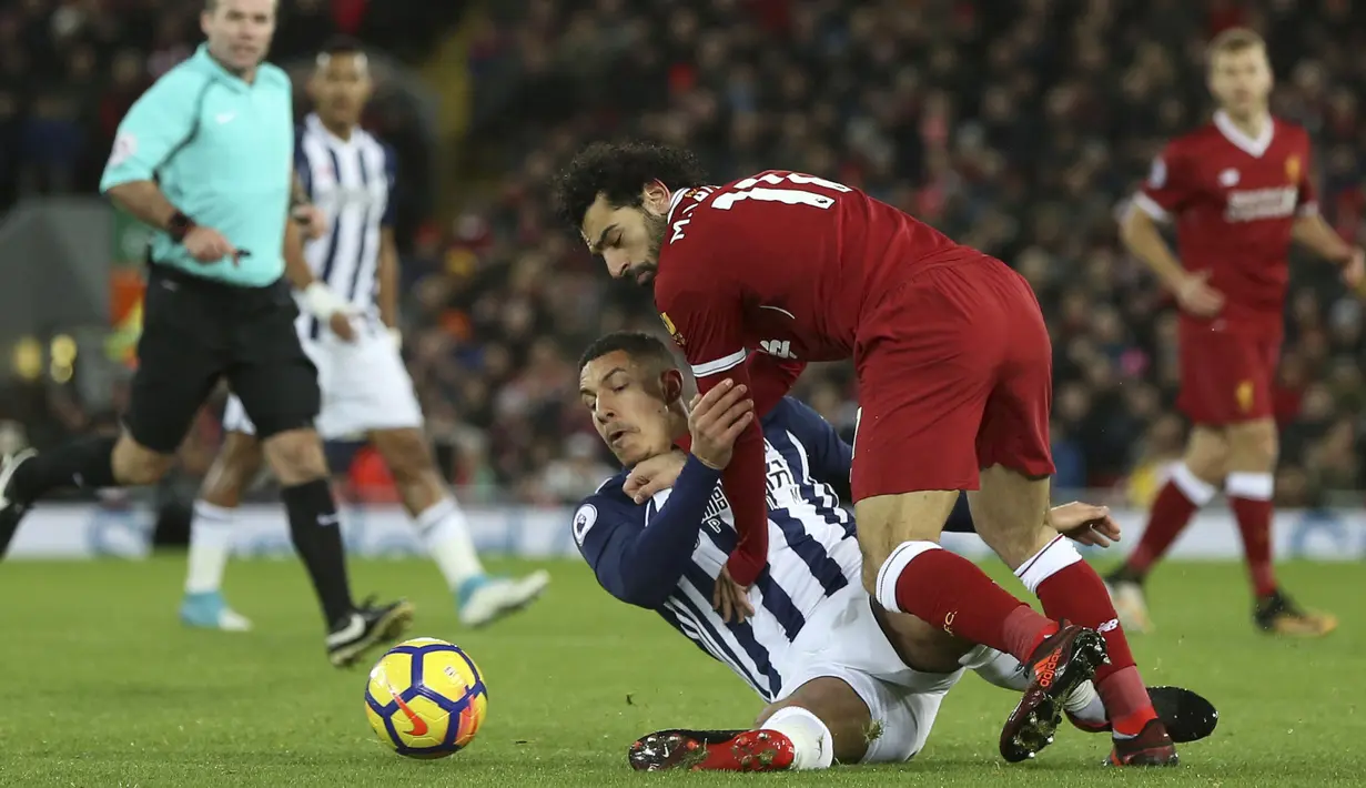 Pemain Liverpool, Mohamed Salah (atas) berebut bola dengan pemain West Brom, Jake Livermore pada lanjutan Premier League di Anfield, Liverpool, (13/12/2017). Liverpool bermain imbang 0-0. (Peter Byrne/PA via AP)