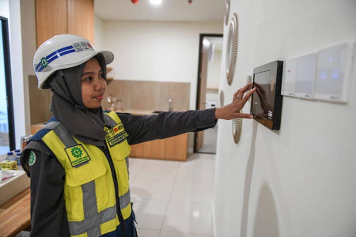 Pekerja mencoba alat pengatur rumah pintar (smart home control) di unit Rusun ASN di IKN