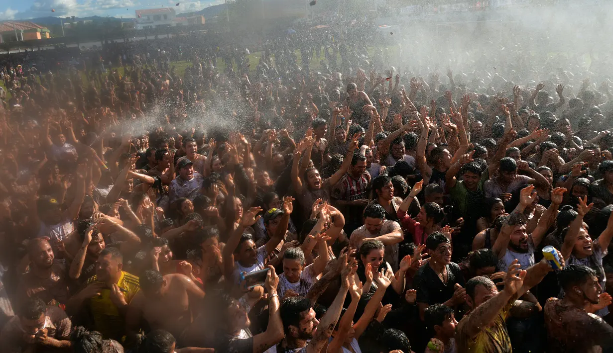 Peserta antusias untuk mengikuti perang tomat dalam Festival Tomatina di Sutamarchan, Boyaca, Kolombia, Minggu (2/6/2019). Perang tomat digelar dengan tujuan menarik wisatawan untuk berkunjung ke Kolombia. (Diana SANCHEZ/AFP)