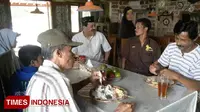 Pemilik restoran fakir miskin gratis, Habib Isyam (kopiah hitam) saat menemani beberapa warga yang sedang menikmati hidangannya di Jalan Ibrahimy, Lingkungan Secang, Kalipuro, Banyuwangi, Jawa Timur. (Foto: Hafil Ahmad/TIMES Indonesia)