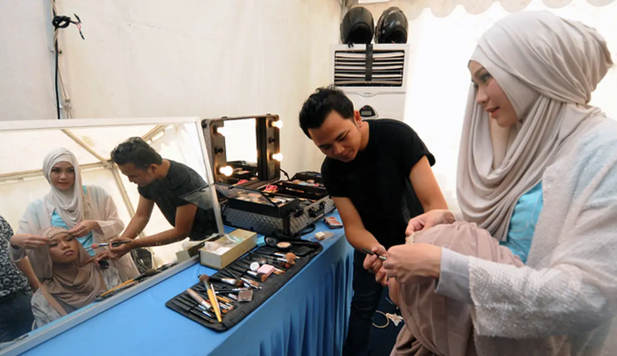 Aktris, Zaskia Adya Mecca (kanan) merapikan kerudung yang dikenakan Wiwi Handayani saat dirias jelang tampil di panggung inBox SCTV di Cibinong Square, Bogor, Jumat (30/1/2015). (Liputan6.com/Helmi Fithriansyah)