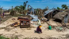 Seorang wanita melintasi rumah-rumah yang hancur akibat topan Kenneth pada bulan lalu di desa pesisir Guludo, Pulau Ibo, 13 Mei 2019. Umat Islam di Mozambik melalui bulan Ramadan dengan badai yang menyebabkan sebagian besar masjid hancur dan persediaan makanan sangat terbatas. (Zinyange Auntony/AFP)