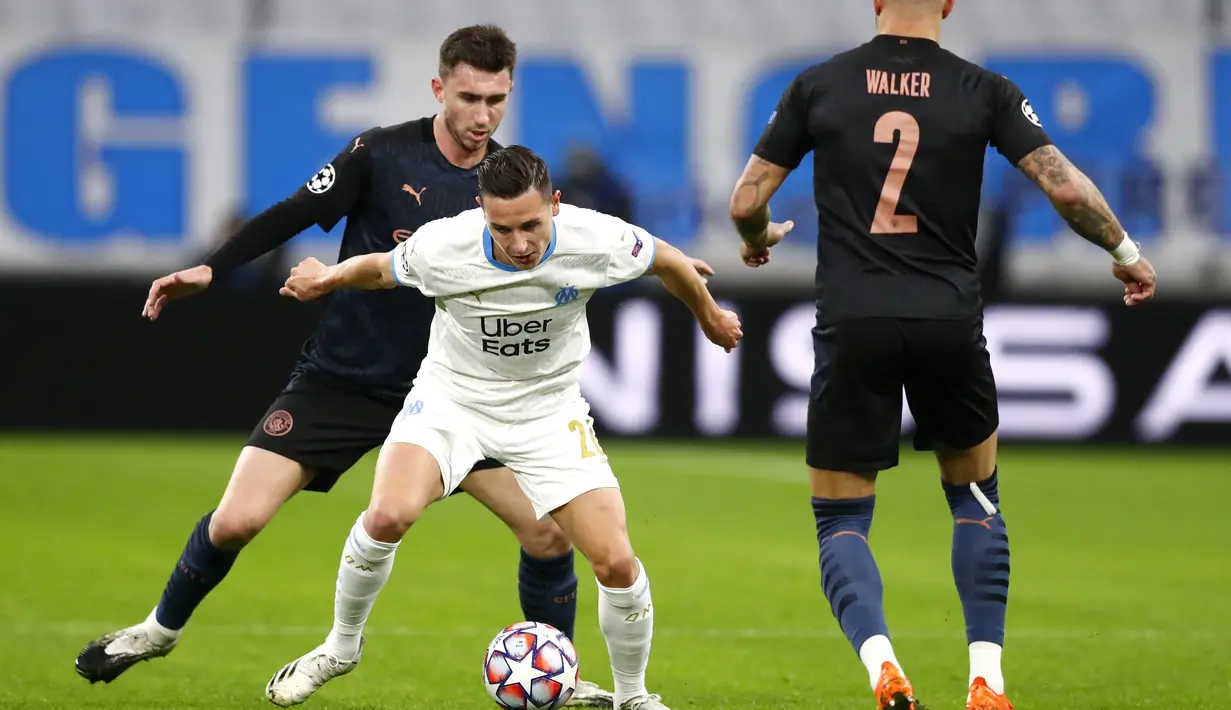 Bek Marseille, Florian Thauvin mengontrol bola dari kawalan bek Manchester City, Aymeric Laporte dan Kyle Walker  pada pertandingan grup C Liga Champions di Stade Velodrome di Marseille, Prancis, Selasa (27/10/2020). City menang telak 3-0 atas Marseille. (Guillaume Horcajuelo/Pool via AP)