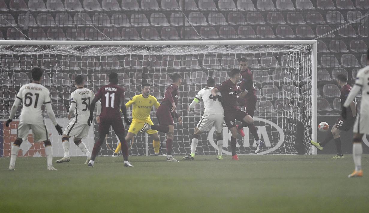Striker CFR Cluj, Gabriel Debeljuh (kanan), membuat gol bunuh diri dalam laga lanjutan Liga Europa 2020/21 Grup A melawan AS Roma di Cluj-Napoca, Rumania, Kamis (26/11/2020) waktu setempat. CFR Cluj kalah 0-2 dari AS Roma. (AFP/Alex Nicodim)