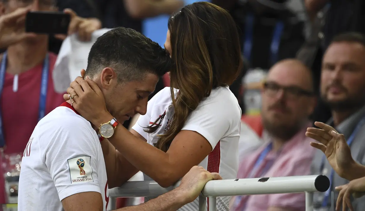 Bintang timnas Polandia, Robert Lewandowski dihibur istrinya seusai dikalahkan Senegal pada pertandingan pertamanya di Piala Dunia 2018 di Stadion Spartak, Moskow, Selasa (19/6). Polandia dikalahkan Senegal 1-2 pada penyisihan grup H. (FRANCK FIFE/AFP)