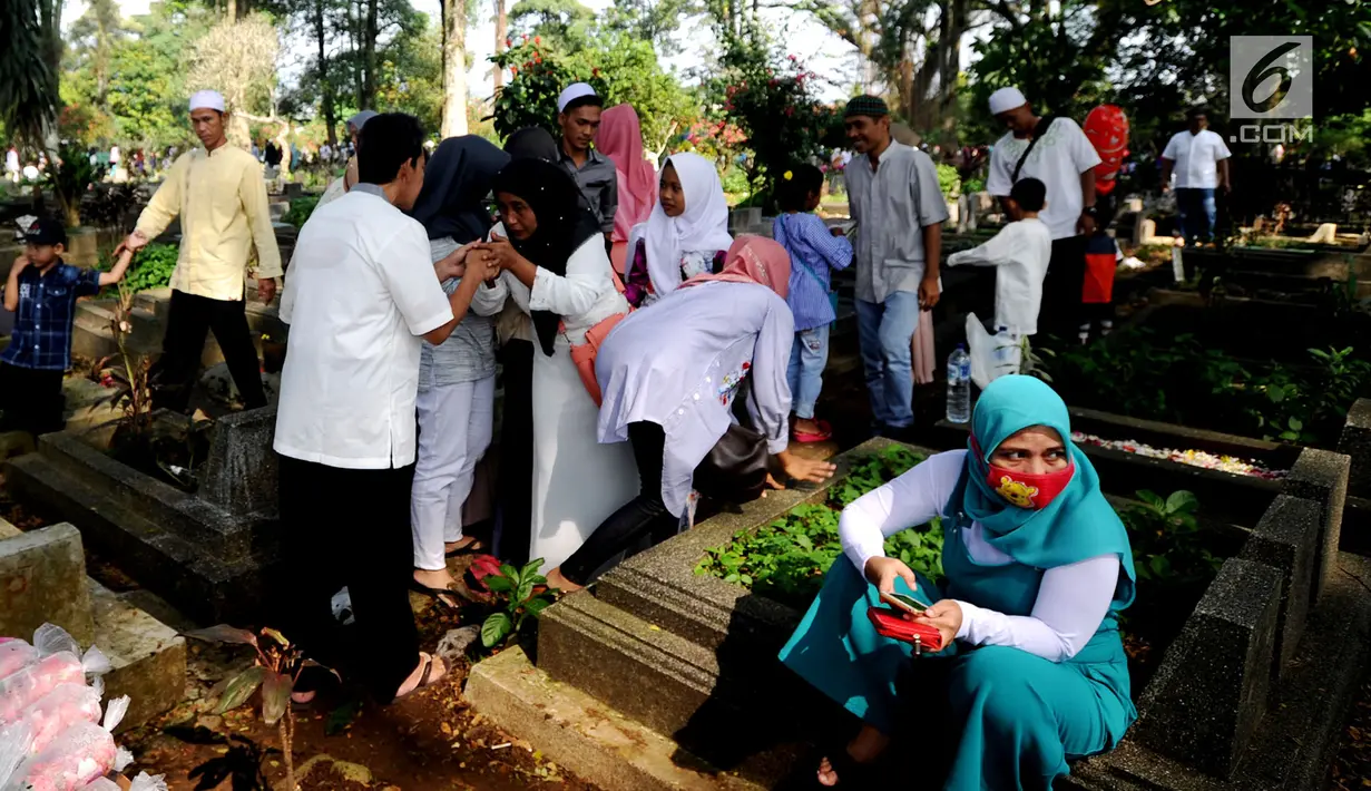 Sejumlah warga melakukan ziarah kubur di TPU Dreded  Bogor (15/6). Hari Raya Idul Fitri 1439 H dimanfaatkan warga untuk melakukan ziarah kubur bagi keluarga dan kerabat yang sudah meninggal. (Merdeka.com/Arie Basuki)