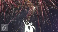 Patung monumen selamat datang dihiasi kembang api saat malam pergantian tahun di kawasan Bundaran HI, Jakarta, Sabtu (31/12). Ribuan warga yang memadati kawasan tersebut tak henti-hentinya meletupkan kembang api ke udara. (Liputan6.com/Immanuel Antonius)