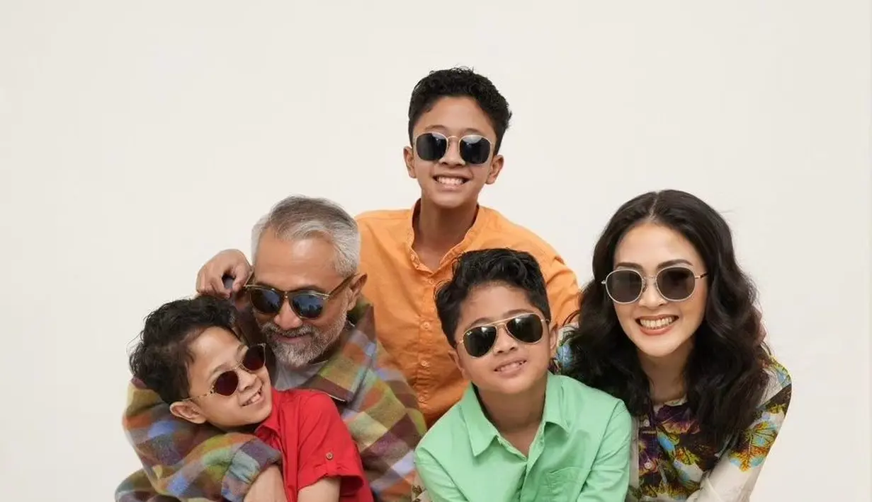 Dengan gaya chic, Lukman Sardi mengenakan flanel, dipadu dengan celana beige. Sedangkan sang istri tampil simpel dengan dress flora lengan panjang. Ketiga putranya kompak mengenakan kemeja berwarna-warni dengan celana pendek. [Foto: Instagram/lukmansrd]