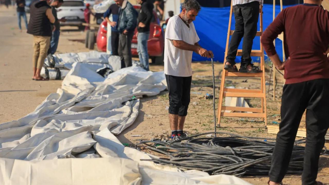 Pengungsi Palestina yang baru tiba dari Khan Yunis langsung membangun tempat tinggal darurat di wilayah sekitar kamp di Rafah di tengah pertempuran lanjutan antara Israel dan Hamas   di Jalur Gaza selatan dekat perbatasan dengan Mesir (4/12/2023).<br>