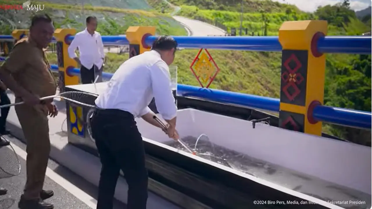 Menteri Agraria Tata Ruang (ATR) Agus Harimurti Yudhoyono (AHY) menangkap ikan bersama Presiden Joko Widodo (Jokowi) saat meresmikan Bendungan Lolak di Sulawesi Utara, Jumat (23/2). (Tangkapan Layar Biro Pers Sekretariat Presiden)