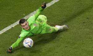 Kiper Kroasia, Dominik Livakovic melakukan penyelamatan penalti saat laga 16 besar Piala Dunia 2022 melawan Jepang yang berlangsung di Al Janoub Stadium,&nbsp;Senin (05/12/2022). (AP/Luca Bruno)