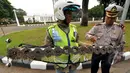 Seorang relawan dari SABER (Sapu Bersih Ranjau Paku) membersihkan ranjau paku di depan Istana Merdeka, Jakarta, Jumat (6/3/2015). Paku yang ditebar oleh orang tidak bertangung jawab seringkali mengganggu para pengguna jalan. (Liputan6.com/Faizal Fanani)