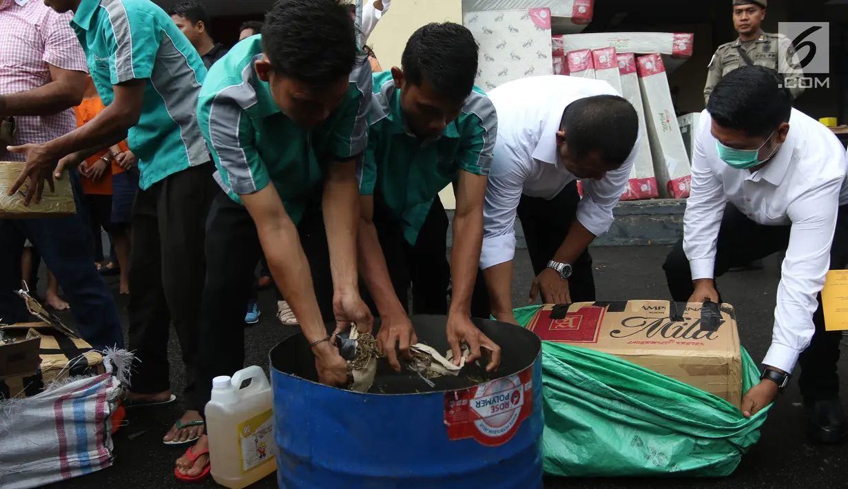 Petugas memusnahkan barang bukti narkoba berupa ganja dan sabu di halaman Polres Jakarta Utara, Senin (19/2). Polres Metro Jakarta Utara memusnahkan sebanyak 42 kg ganja. (Liputan6.com/Arya Manggala)