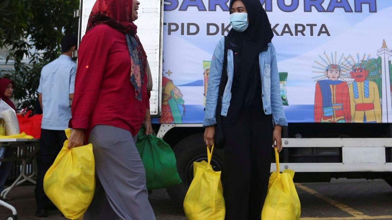 Sejumlah warga usai membeli paket sembako murah di Bazar Ramadan Sembako Murah LRT Jakarta di Jakarta Utara, Senin (25/3/2024). Foto: Liputan6.com / Angga Yuniar