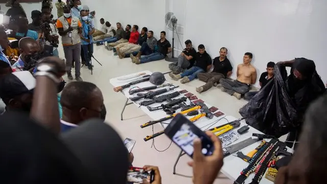Tersangka dalam pembunuhan Presiden Haiti Jovenel Moise, bersama dengan senjata dan peralatan yang diduga mereka gunakan, ditunjukkan kepada media di Port-au-Prince pada 8 Juli 2021 (AP)
