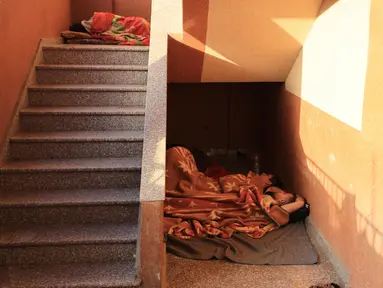 Warga Palestina yang mengungsi dari Jalur Gaza, mencari tempat yang aman untuk tidur di tangga sementara yang lain berkemah di halaman rumah sakit al-Nasser di Khan Yunis di Jalur Gaza selatan, di tengah pertempuran yang sedang berlangsung antara Israel dan Hamas, Kamis (9/11/2023). (Mahmud HAMS / AFP)
