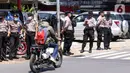 Seorang pengendara sepeda motor melintas dekat sejumlah polisi berjaga di area Pengadilan Negeri Jakarta Selatan, Senin (4/1/2021). Pengamanan ratusan aparat kepolisian dilakukan untuk mengantisipasi pergerakan masa pada saat sidang praperadilan Rizieq Shihab. (Liputan6.com/Angga Yuniar)