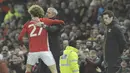 Pelatih Manchester United, Jose Mourinho memeluk anak asuhnya Marouane Fellaini usai gol kedua saat melawan Hull City pada laga semifinal leg pertama PIala Liga Inggris di Old Trafford stadium, Manchester, (10/1/2017). MU menang 2-0. (AP/Rui Vieira)