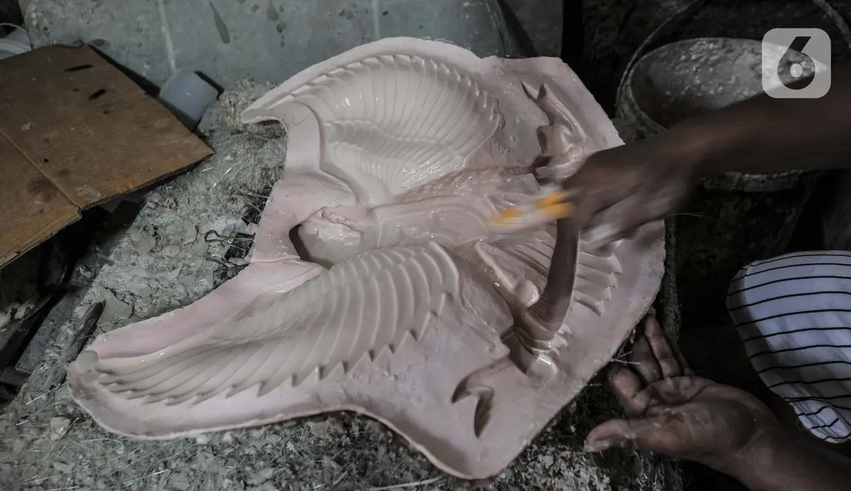 Perajin saat menyelesaikan pembuatan patung Garuda Pancasila di industri rumahan kawasan Bali Raya, Kalimalang, Jakarta Timur, Selasa (1/7/2021). Dalam sehari perajin mampu memproduksi hingga 15 patung Garuda Pancasila. (merdeka.com/Iqbal S. Nugroho)