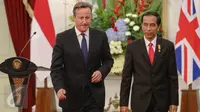 Presiden Jokowi dan PM Inggris David Cameron usai memberikan pernyataan di Istana Negara, Jakarta, Senin (27/7). Keduanya melakukan pertemuan bilateral untuk meningkatkan hubungan kerjasama kedua negara di berbagai bidang. (Liputan6.com/Faizal Fanani)