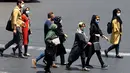 Warga Iran yang mengenakan masker menyeberang jalan di ibu kota Teheran, Sabtu (3/7/2021). Presiden Hassan Rouhani mengaku khawatir Iran akan dilanda gelombang kelima pandemi Covid-19 karena kemunculan virus corona varian Delta. (ATTA KENARE/AFP)