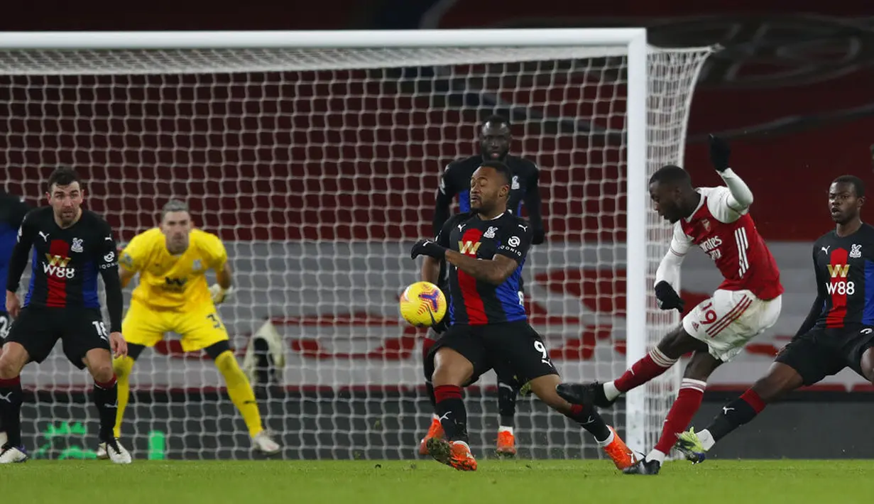 Pemain Arsenal Nicolas Pepe (kanan) menembak bola saat melawan Crystal Palace pada pertandingan Liga Inggris di Emirates Stadium, London, Inggris, Kamis (14/1/2021). Pertandingan berakhir imbang 0-0. (AP Photo/Alastair Grant, Pool)