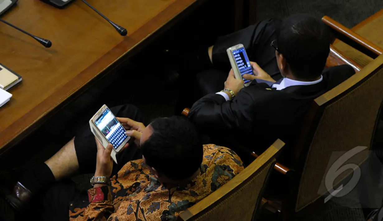 Saat rapat Paripurna sejumlah anggota dewan sibuk dengan ponselnya. Dua orang anggota dewan terlihat sedang mengamati ponselnya saat rapat Paripurna DPR, Jakarta (09/02/2015). (Liputan6.com/Andrian M Tunay)