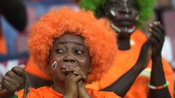 Reaksi supporter Pantai Gading di akhir adu penalti babak 16 besar Piala Afrika 2022 antara timnya dan Mesir di Stade Omnisport de Douala, Rabu (26/1/2022). Mesir melangkah ke perempat final setelah menyingkirkan Pantai Gading lewat drama adu penalti dengan skor 5-4 (0-0). (AP Photo/Themba Hadebe)