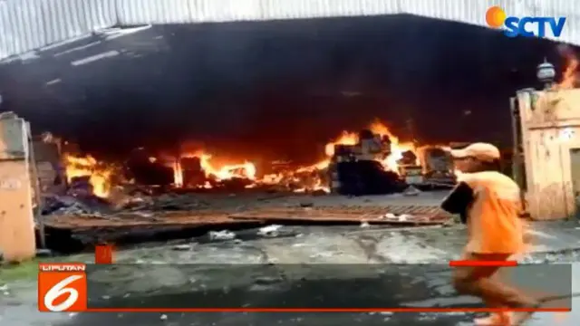 Warga berusaha memadamkan kobaran api yang melalap hampir seluruh bagian pabrik.