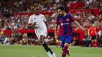 Ilkay Gundogan dari Barcelona, kanan, berebut bola dengan Tanguy Nianzou dari Sevilla selama pertandingan sepak bola La Liga Spanyol antara Sevilla dan FC Barcelona di stadion Ramon Sanchez Pizjuan di Seville, Spanyol, Minggu, 26 Mei 2024. (AP Photo/Fermin Rodriguez )