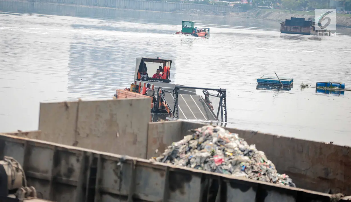 Kendaraan eskavator dan tongkang Dinas Tata Air DKI Jakarta mengeruk lumpur dan sampah dari Waduk Pluit, Jakarta, Selasa (11/12). Pengerukan ini rutin dilakukan oleh Dinas Tata Air DKI Jakarta. (Liputan6.com/Faizal Fanani)