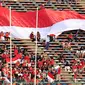 Pendukung Indonesia membentangkan bendera Merah Putih raksasa saat laga kedua Grup A Sepak Bola SEA Games 2023 antara Timnas Indonesia melawan Timnas Myanmar di Olympic Stadium, Phnom Penh, Kamboja, Kamis (04/05/2023). Skuad asuhan Indra Sjafri tersebut berhasil menang dengan skor telak 5-0. (Bola.com/Abdul Aziz)