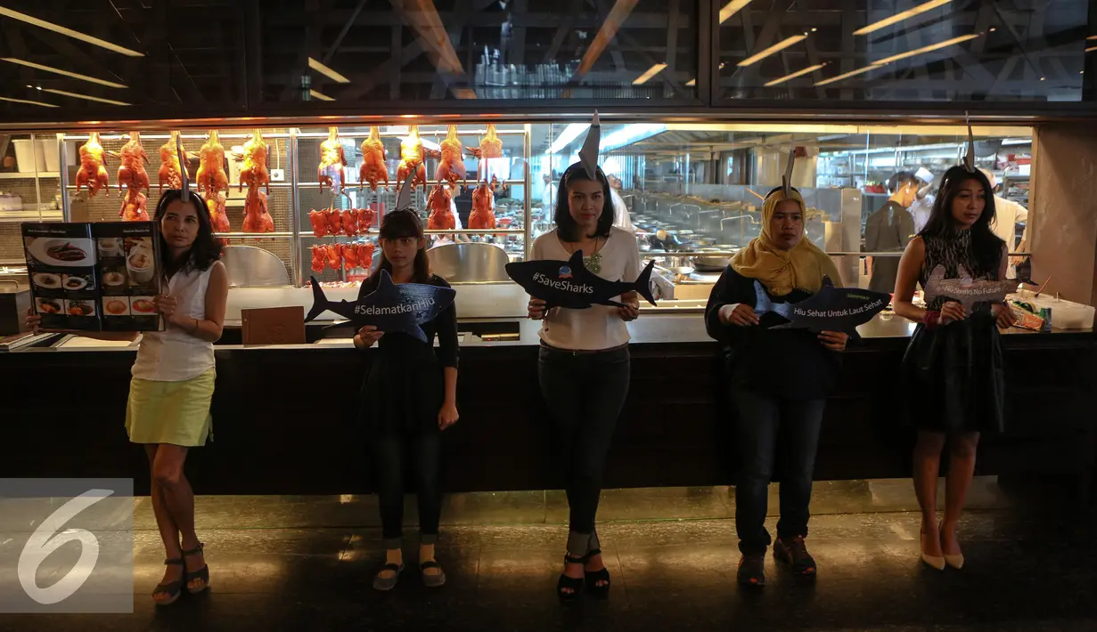 Sejumlah aktivis Greenpeace Indonesia menggelar kampanye selamatkan hiu (savesharks) di salah satu rumah makan, Jakarta, Minggu (12/7/2015). Aksi tersebut sebagai upaya menyelamatkan hiu dari kepunahan. (Liputan6.com/Faizal Fanani)