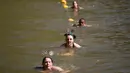Peserta berenang di bendungan selama lomba lari Strongman Run di kota Paarl, Afrika Selatan, 13 Oktober 2018. Karena peserta yang semakin bertambah, Strongman Run kini diadakan beberapa kali setahun di berbagai negara di Eropa. (RODGER BOSCH/AFP)