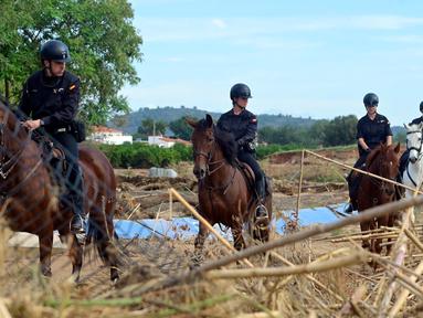 Petugas keamanan berkuda mencari korban di Cheste, wilayah Valencia, Spanyol timur, pada Jumat 8 November 2024. (JOSE JORDAN/AFP)