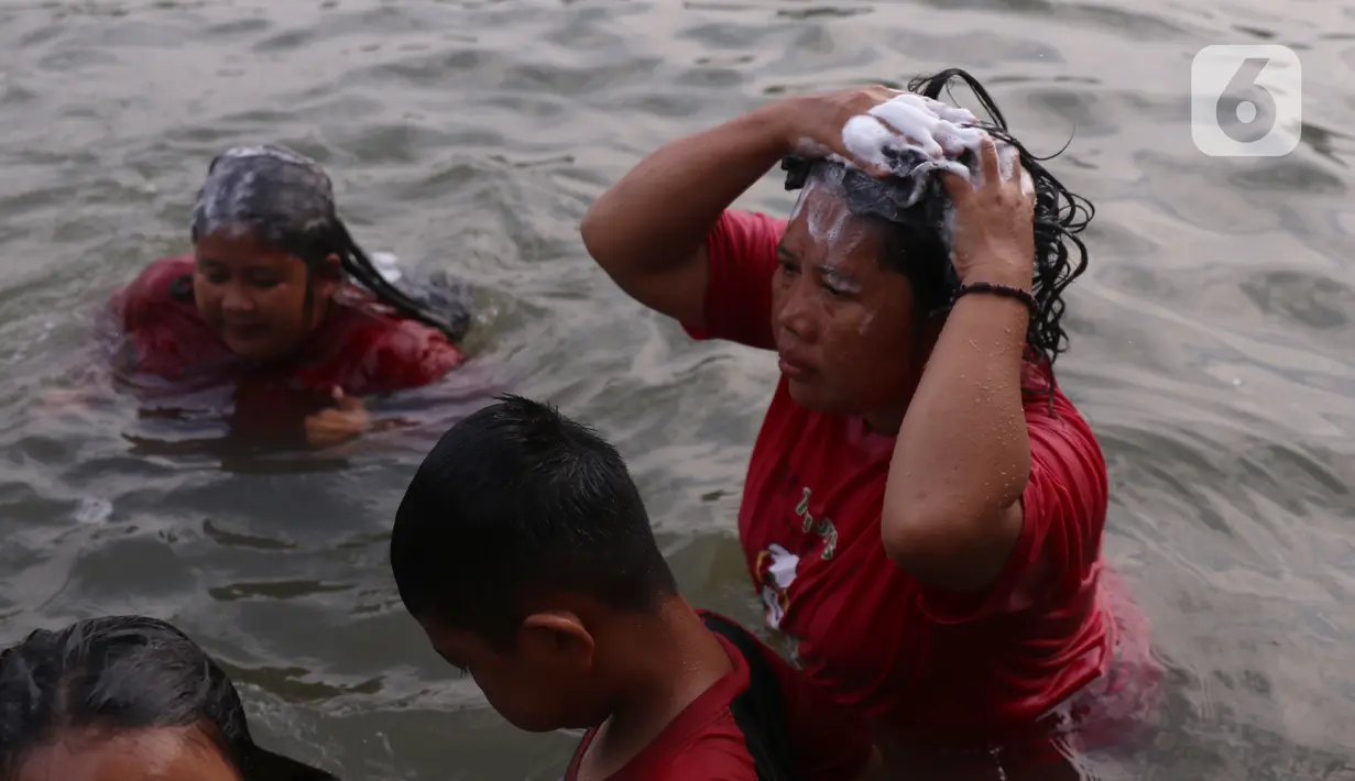 Warga melakukan keramas bersama di bantaran sungai Cisadane di kawasan Babakan, Kota Tangerang, Jumat (1/4/2022). Keramas bersama merupakan tradisi warga yang berada dikawasan tersebur sebagai simbol membersihkan diri untuk menyambut bulan Ramadhan. (Liputan6.com/Angga Yuniar)