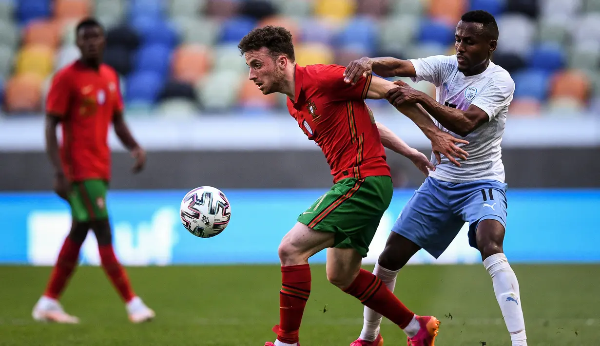 Striker Portugal, Diogo Jota (kiri) menguasai bola dibayangi gelandang Israel, Gadi Kinda dalam laga uji coba menjelang Euro 2020 di Jose Alvalade Stadium, Lisbon, Rabu (9/6/2021). Portugal menang 4-0 atas Israel. (AFP/Patricia De Melo Moreira)