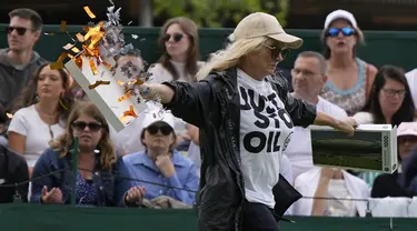 Seorang pengunjuk rasa Just Stop Oil berlari ke Court 18 dan melepaskan confetti pada hari ketiga kejuaraan tenis Wimbledon di London, Rabu, 5 Juli 2023. (AP Photo/Alastair Grant)