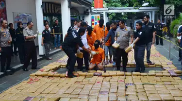 Petugas menunjukkan tersangka dan barang bukti narkoba jenis ganja saat rilis di Polda Metro, Jakarta, Senin (30/7). Sebanyak 1.434 kg ganja jaringan Aceh-Jakarta-Bogor diamankan petugas berikut 6 orang tersangka. (Merdeka.com/Arie Basuki)