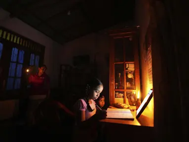 Gadis Sri Lanka menggunakan lampu minyak tanah untuk sekolah online saat pemadaman listrik di Kolombo, 4 Maret 2022. Krisis keuangan negara memaksa anak-anak belajar menggunakan lampu minyak tanah, nelayan mengurangi penangkapan ikan dan industri membatasi produksi. (AP Photo/Eranga Jayawardena)