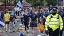 Penggemar Skotlandia berjalan di antara sampah yang ditinggalkan oleh penggemar yang berpesta sebelum pertandingan grup D kejuaraan sepak bola Euro 2020 antara Inggris dan Skotlandia, di London, Jumat (18/6/2021).  (AFP/Tolga Akmen)
