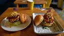Burger "Durty Donald" dan "Kim Jong Yum" yang baru dibuat di sebuah restoran di Hanoi, Vietnam, 21 Februari 2019. Menu baru ini terinspirasi pertemuan puncak antara Presiden AS Donald Trump dan pemimpin Korut, Kim Jong-un. (Manan VATSYAYANA/AFP)