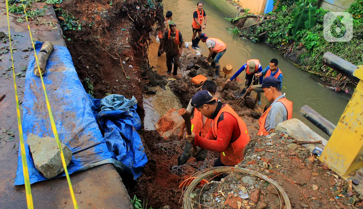 Pekerja melakukan perbaikan salah satu sisi Jalan Raya Tanah Baru yang mengalami longsor, Depok, Jawa Barat, Kamis (9/1/2020). Sebelumnya, beberapa titik sepanjang Jalan Raya Tanah Baru mengalami longsor akibat hujan deras yang melanda. (merdeka.com/Magang/Muhammad Fayyadh)
