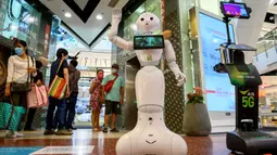 Robot 5G menyambut pengunjung yang mendatangi pusat perbelanjaan di Bangkok, Thailand, Kamis (4/6/2020). Thailand menggunakan teknologi di garis depan untuk menjaga ruang publik dari penyebaran pandemi corona Covid-19. (Mladen ANTONOV / AFP)